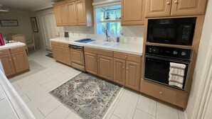 A kitchen with wooden cabinets, a dishwasher, a microwave, and an oven.