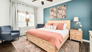 A bedroom with a bed, a chair, a nightstand, a ceiling fan, and artwork on the wall. - ❤︎Families love the location and private, heated pool❤︎ 6-min walk to beach❤︎ (Destin)