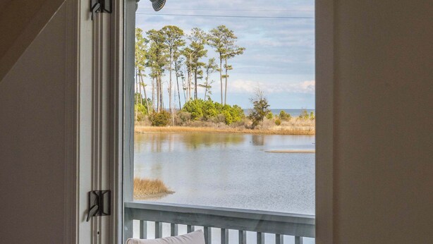 A window with a view of a lake, trees, and a dock. - Waterfront Retreat w/ Hot Tub, Game Room, Kayaks, 2 Kings, + more! (White Stone)