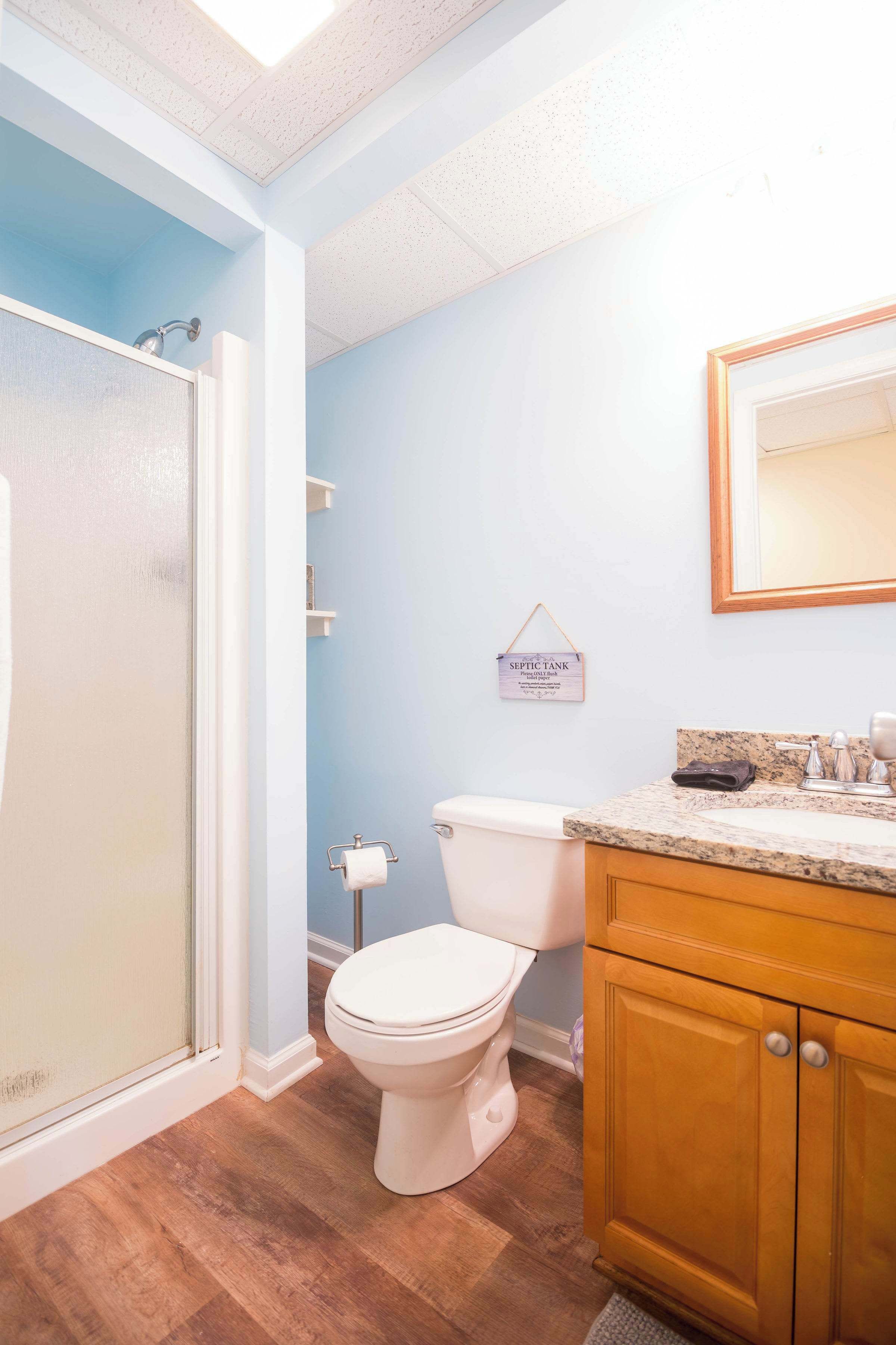 A bathroom with a shower, toilet, and vanity.