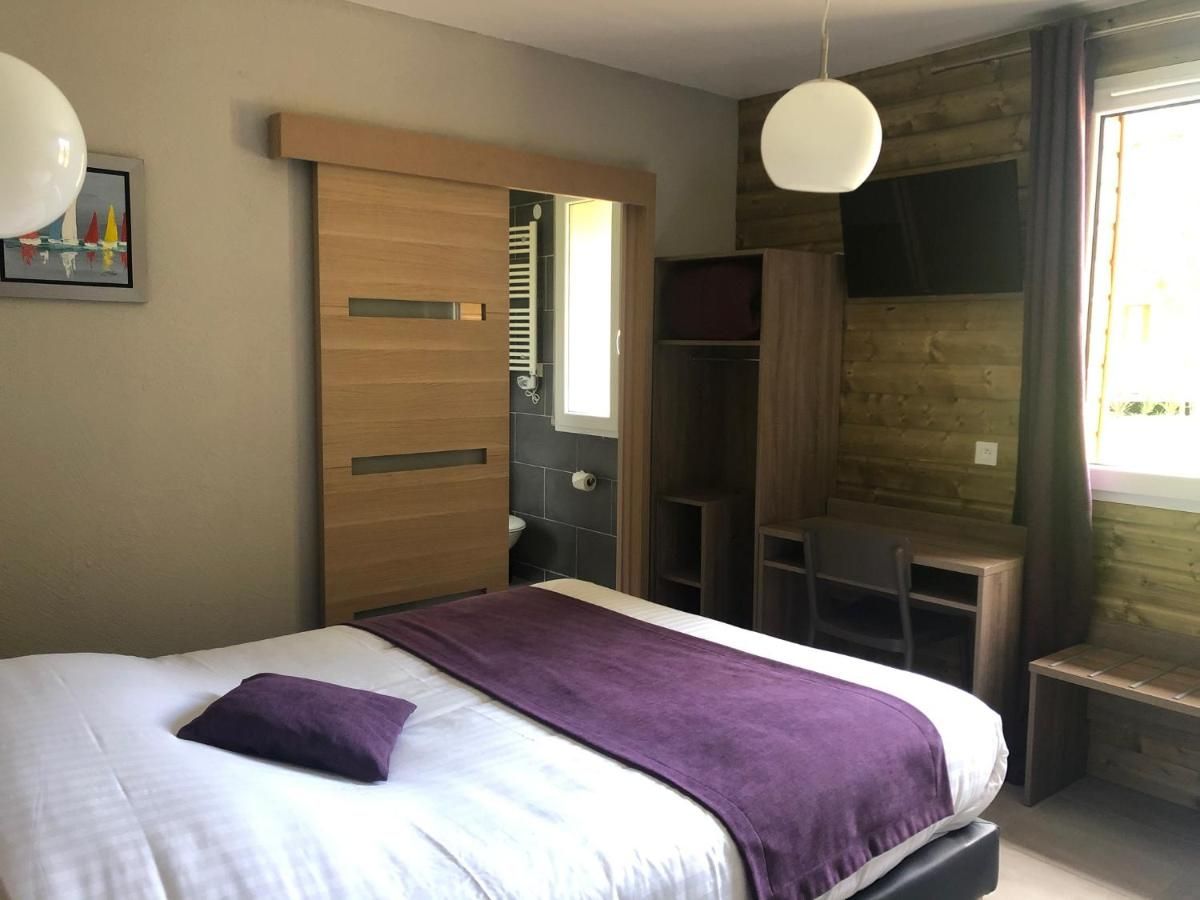 Ein Schlafzimmer mit einem Bett, einem Holzschrank, einem Schreibtisch und einem Stuhl.