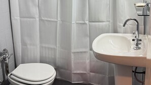 A bathroom with a white shower curtain, a white sink, and a toilet. - Diplomat Hotel  (Buenos Aires)