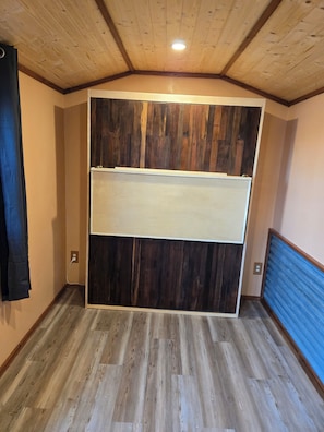 A room with a wooden ceiling, a large wall panel, and a blue wall. - Your lakeside oasis awaits: perfect for families and fun! (Hackensack)