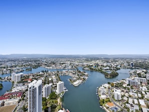A coastal cityscape with a river meandering through it, surrounded by residential and commercial buildings.