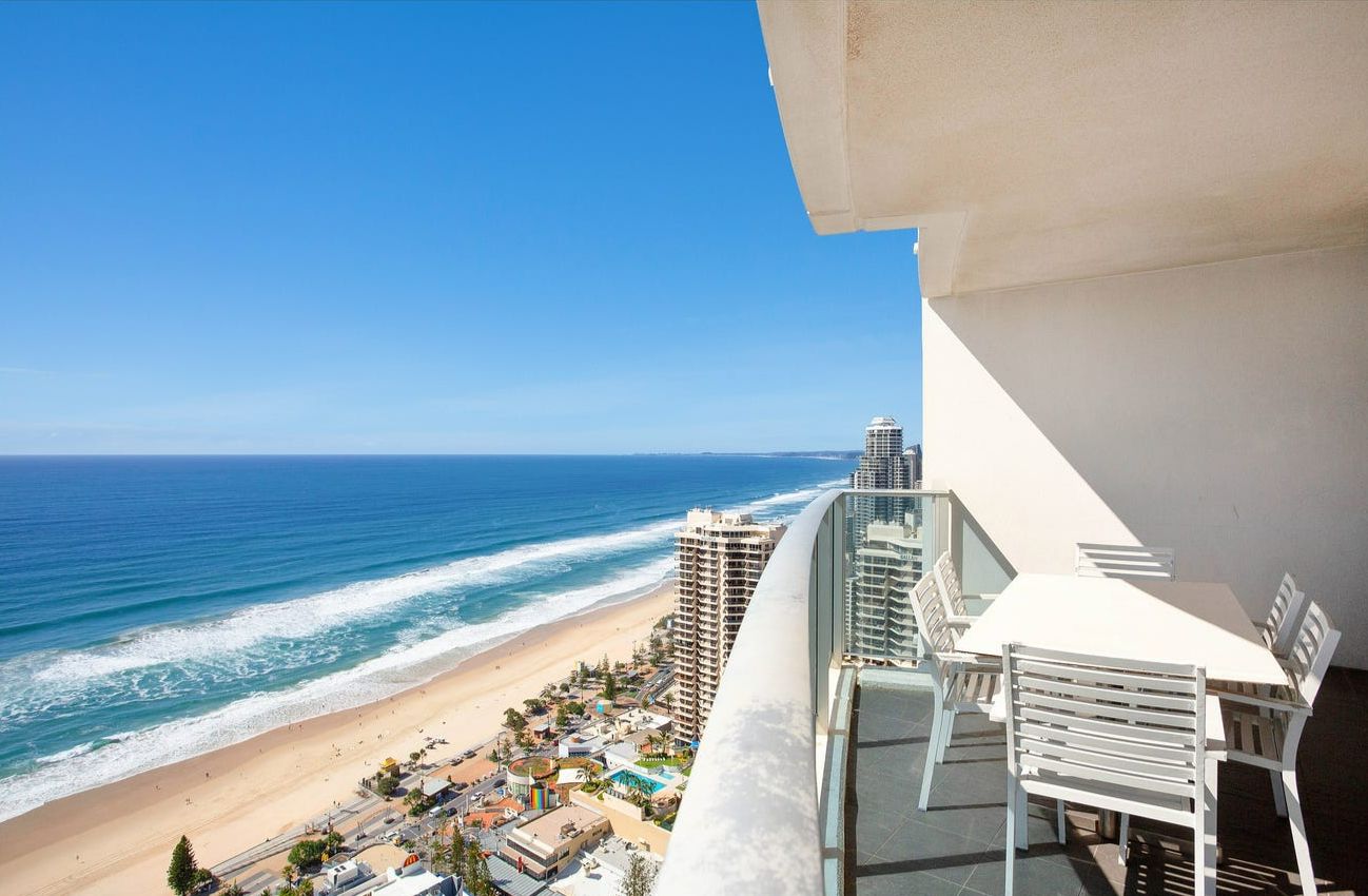 A balcony with a view of a beach and ocean.