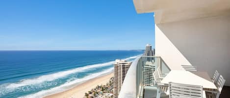 A balcony with a view of a beach and ocean.