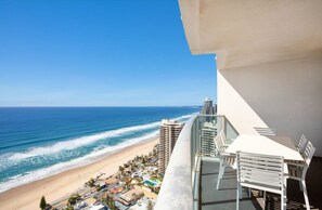 Een balkon met uitzicht op een strand en de oceaan.