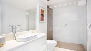 A modern bathroom with a white sink, mirror, and toilet. - Charming Level 35 Central Getaway (Gold Coast)