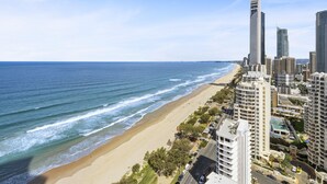 A coastal cityscape with a beachfront, high-rise buildings, and a clear sky. - Luxury Oceanview Apartment with Balcony (Surfers Paradise)