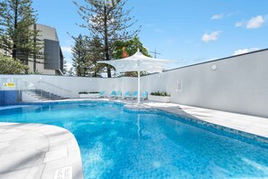 Relax by the pool surrounded by comfortable lounge chairs and a staircase leading down to the water.