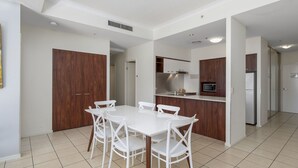 A modern kitchen with white cabinets, a stainless steel refrigerator, and a microwave.
