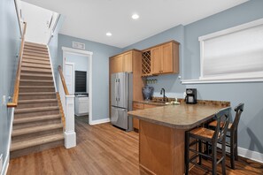 A kitchen with a wooden island, stainless steel appliances, and a view of the living area.