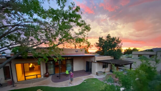 A modern house with a patio, a dog, and a small garden.