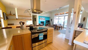 A modern kitchen with a central island, stainless steel appliances, and wooden cabinetry.