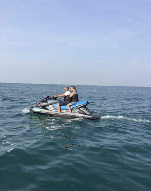 Zwei Personen fahren mit einem Jetski auf dem Wasser.