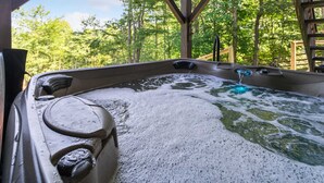 A hot tub with a wooden deck and a view of a forest. - Mountain Cottage on Ski Slopes (Blowing Rock)