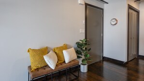 Un espace d’attente moderne, comprenant un banc, une plante en pot et une horloge murale.