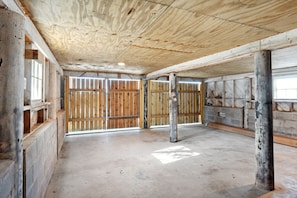 Une pièce spacieuse avec un plafond haut, des murs en bois et un plancher en béton.