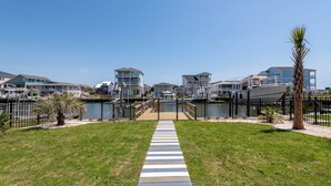 Un chemin menant à une marina où sont amarrés des bateaux, le tout étant entouré d’immeubles d’habitation.