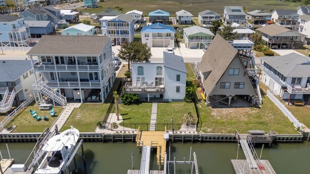 Une zone résidentielle côtière avec des maisons, un quai et un bateau.