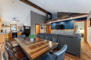 Une cuisine moderne avec des meubles en bois, une table à manger et un four encastré.