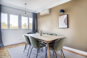 Enjoy meals in this dining area with a large window offering a view of the surrounding trees.