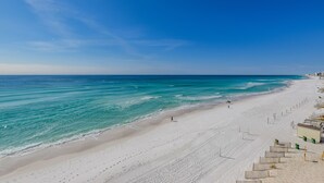 Een strand met heldere lucht, rustige zee en een zandrijk strand.