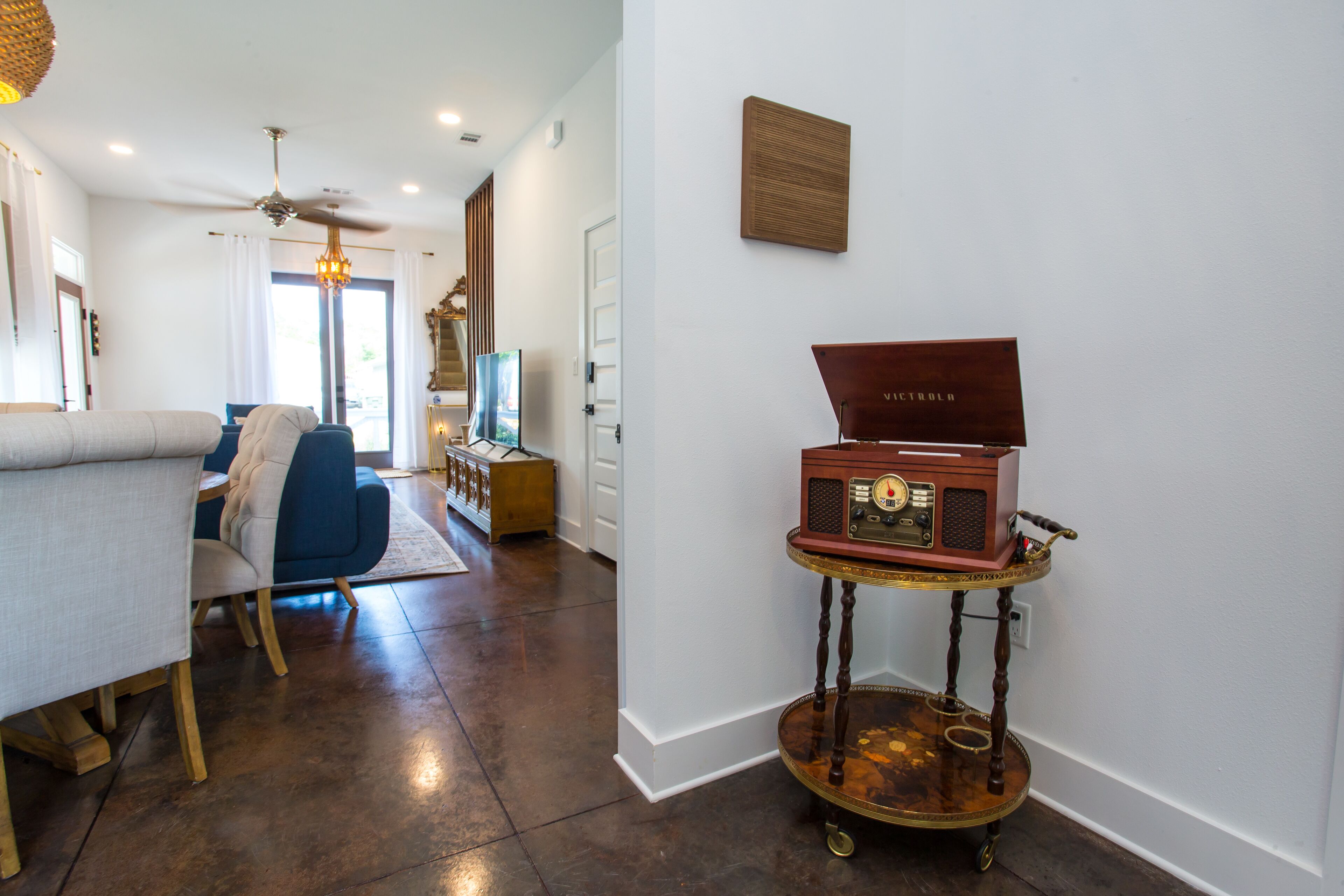 Una sala de estar moderna con un sofá, una mesita de centro y una radio antigua sobre un soporte.