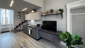 Eine moderne Küche mit Kochinsel, eingebauten Geräten und einem Flachbildfernseher.