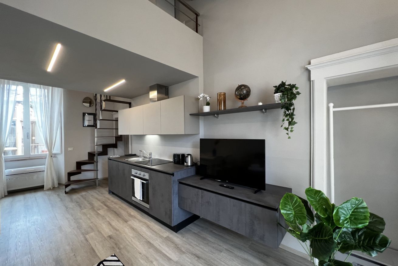 A modern kitchen with a central island, built-in appliances, and a flat-screen TV.