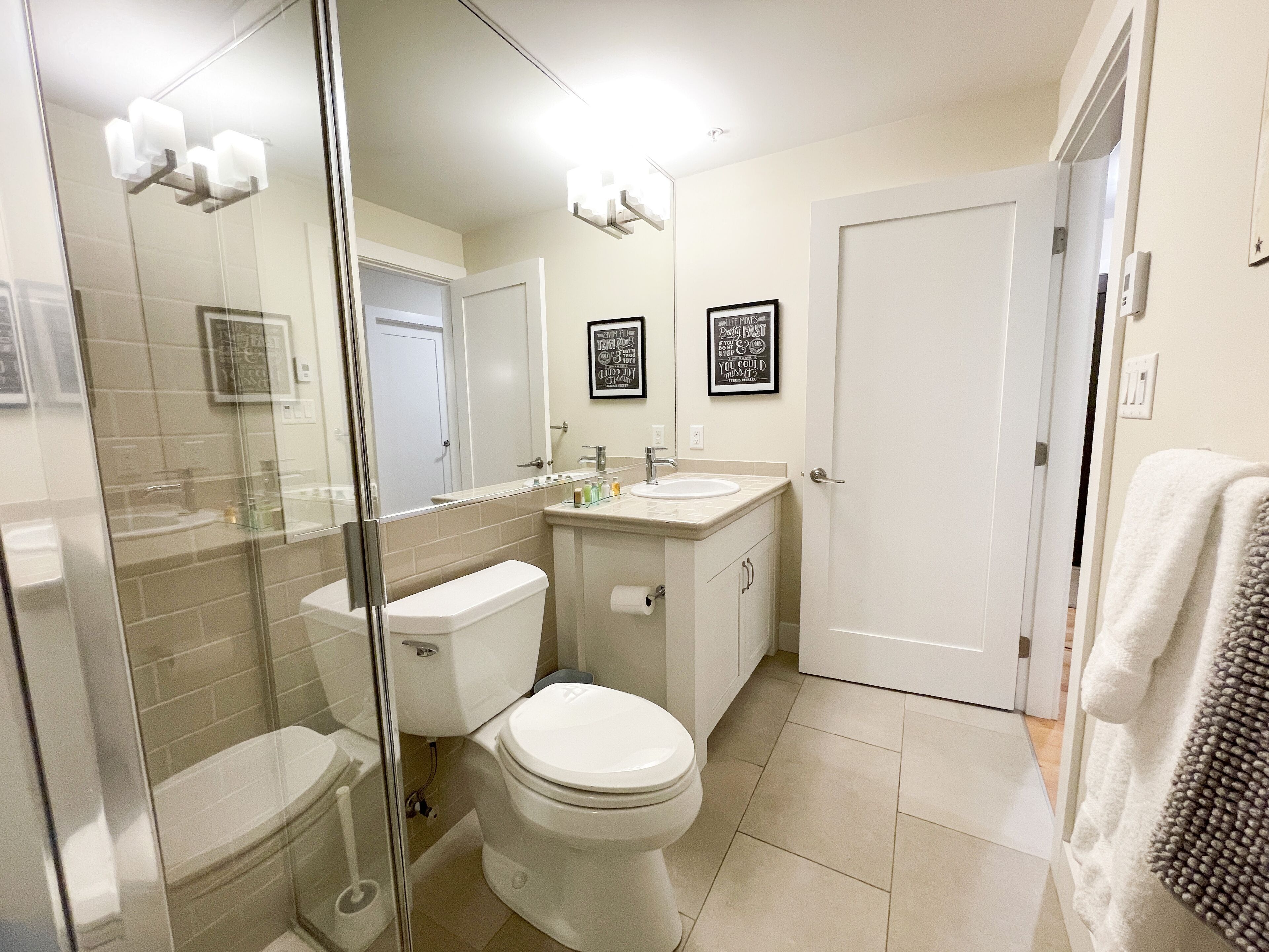 Une salle de bain comprenant des toilettes, un lavabo et un espace douche.