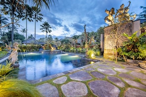 Una piscina al aire libre, sombrillas, sillones reclinables de piscina