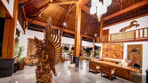 Un hall d’entrée spacieux, doté d’un plafond haut, de poutres en bois et d’une sculpture décorative centrale.