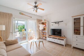 A modern living room with a sofa, TV stand, and a ceiling fan. - CostaBlancaDreams - Casa Alis in Calpe (Calpe / Calp)