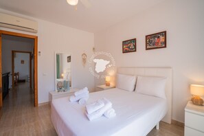 A hotel room with a large bed, a bedside table with a lamp, a mirror, and artwork on the wall. - CostaBlancaDreams - Casa Alis in Calpe (Calpe / Calp)