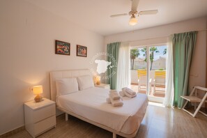 A bedroom with a bed, nightstands, a ceiling fan, and a view of the outside balcony. - CostaBlancaDreams - Casa Alis in Calpe (Calpe / Calp)