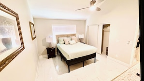 A bedroom with a bed, nightstands, a ceiling fan, a wardrobe, and a window with blinds. - Tempe town house near ASU. only 2 miles away. (Tempe)