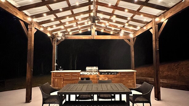 An outdoor covered patio area with a wooden table and chairs, a grill, and a sign that reads "TIKI BAR". - Ellijay Mountain Escape with Private Pool, Fire Pit, & BBQ! (Ellijay)