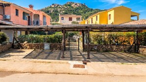 A courtyard with a pergola, stone walls, and buildings with traditional architecture. - Il Glicine 1.5 Km From The Beach, Vaccileddi, Italy (Vaccileddi)