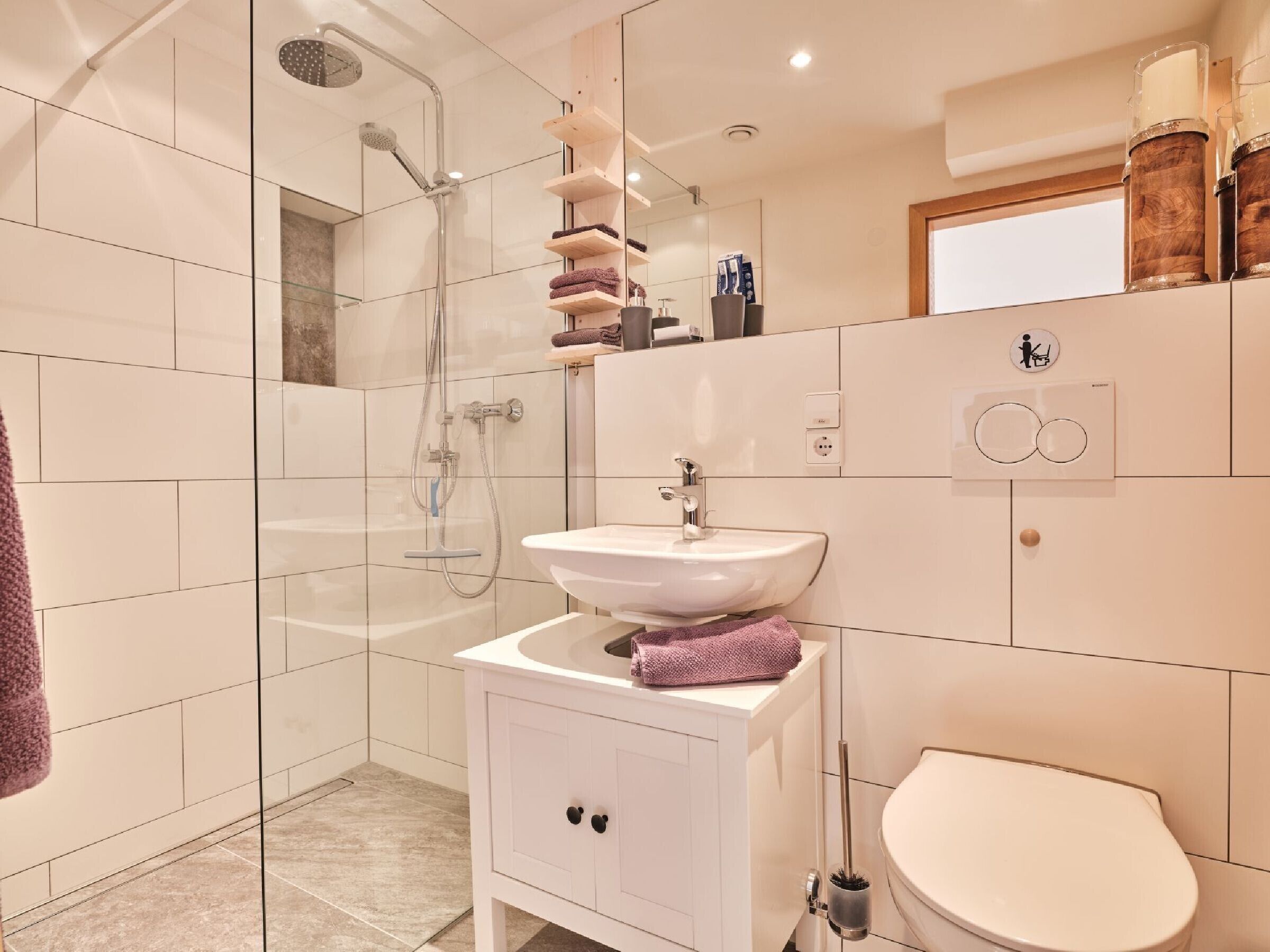 Une salle de bain moderne avec une douche à parois de verre, un lavabo blanc et des toilettes.