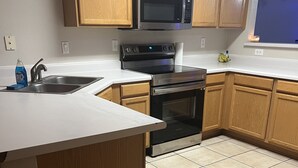 A kitchen with wooden cabinets, a stainless steel microwave, a double oven, and a white countertop. - Swanky Super Bowl House 2 miles from Stadium. (PHOENIX)