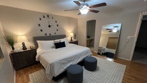 A bedroom with a bed, bedside tables, a ceiling fan, a wall clock, and a mirror. - Swanky Super Bowl House 2 miles from Stadium. (PHOENIX)
