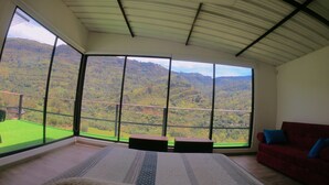 Une chambre dotée d’une grande fenêtre donnant sur un paysage montagneux.