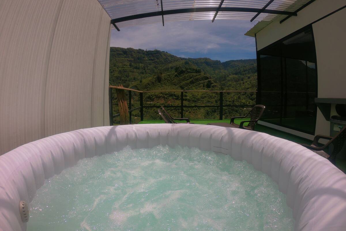 A hot tub with a view of a mountainous landscape.