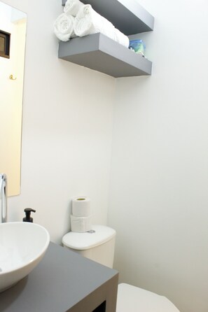 Un baño con lavabo, inodoro y espacio para toallas.