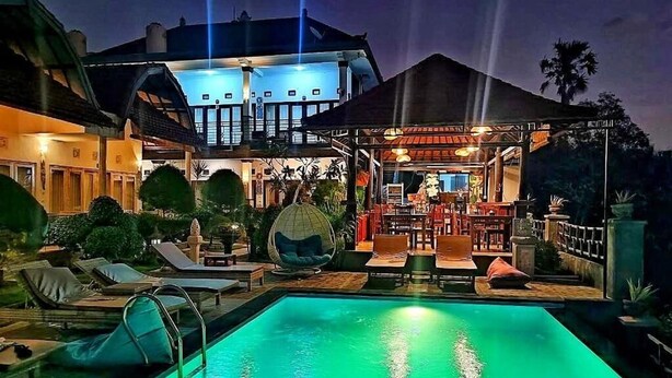 A pool area with lounge chairs and a bar area with tables and chairs. - Kaylas Hill Resort (Penida Island)