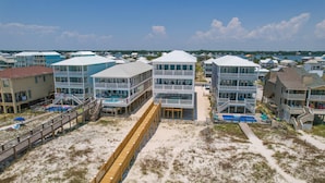 A beachfront property with multiple buildings, including a pool area and a boardwalk.