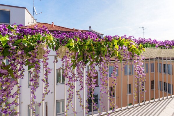 A building with a balcony covered in purple flowers.