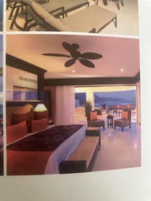 Ein Hotelzimmer mit Bett, Sitzgelegenheit und Blick ins Freie.