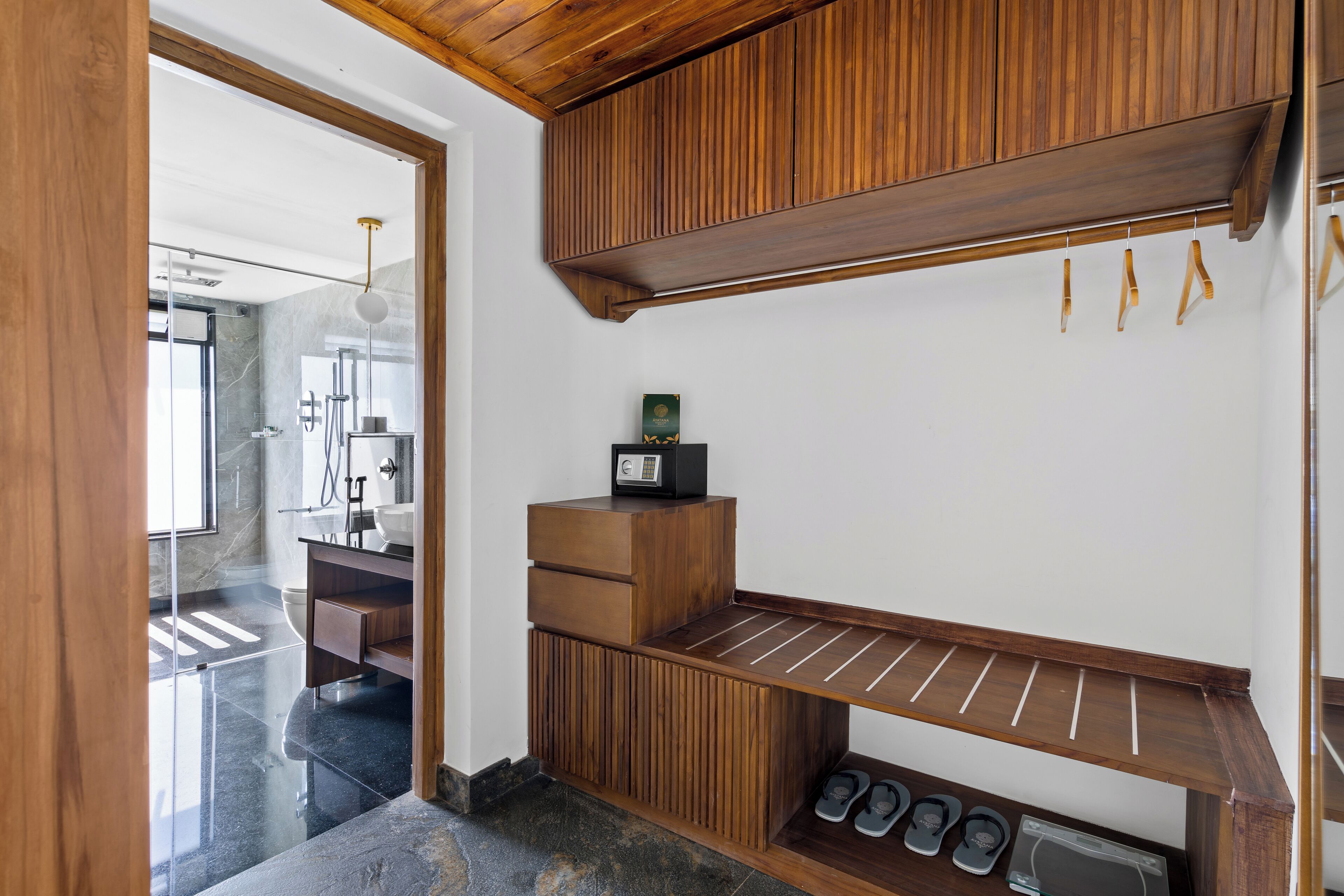 A modern bathroom with a wooden vanity, a towel rack, and a shoe rack.